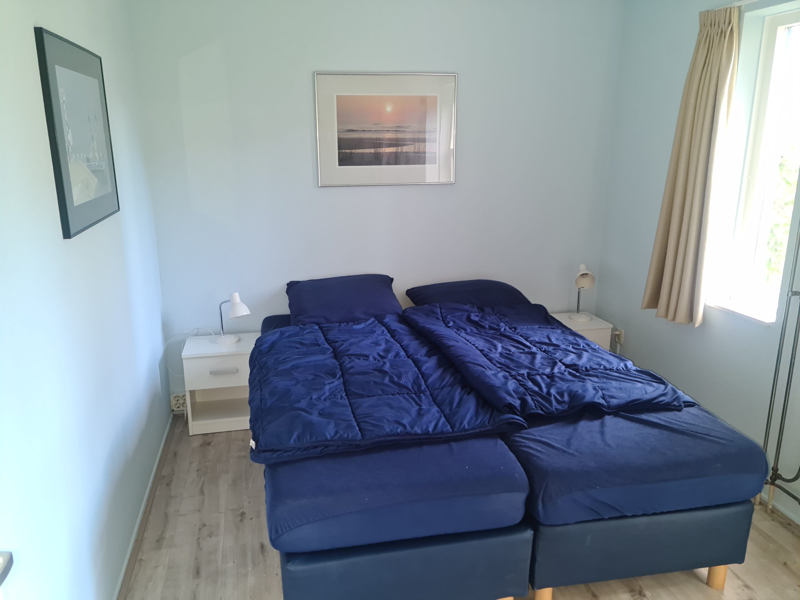 Slaapkamer beneden met twee losse eenpersoonsbedden en een grote houten kast.