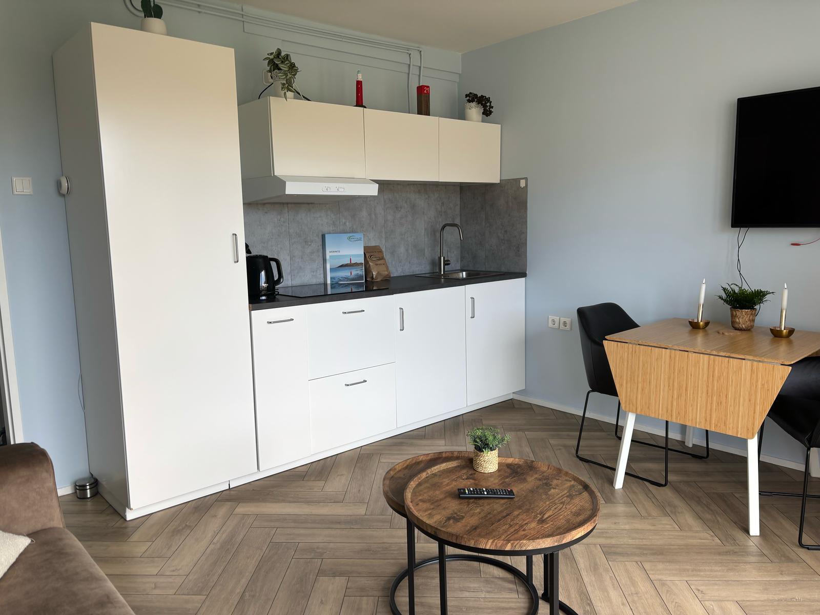 Woonkamer met aan de linkerkant het keukenblok.