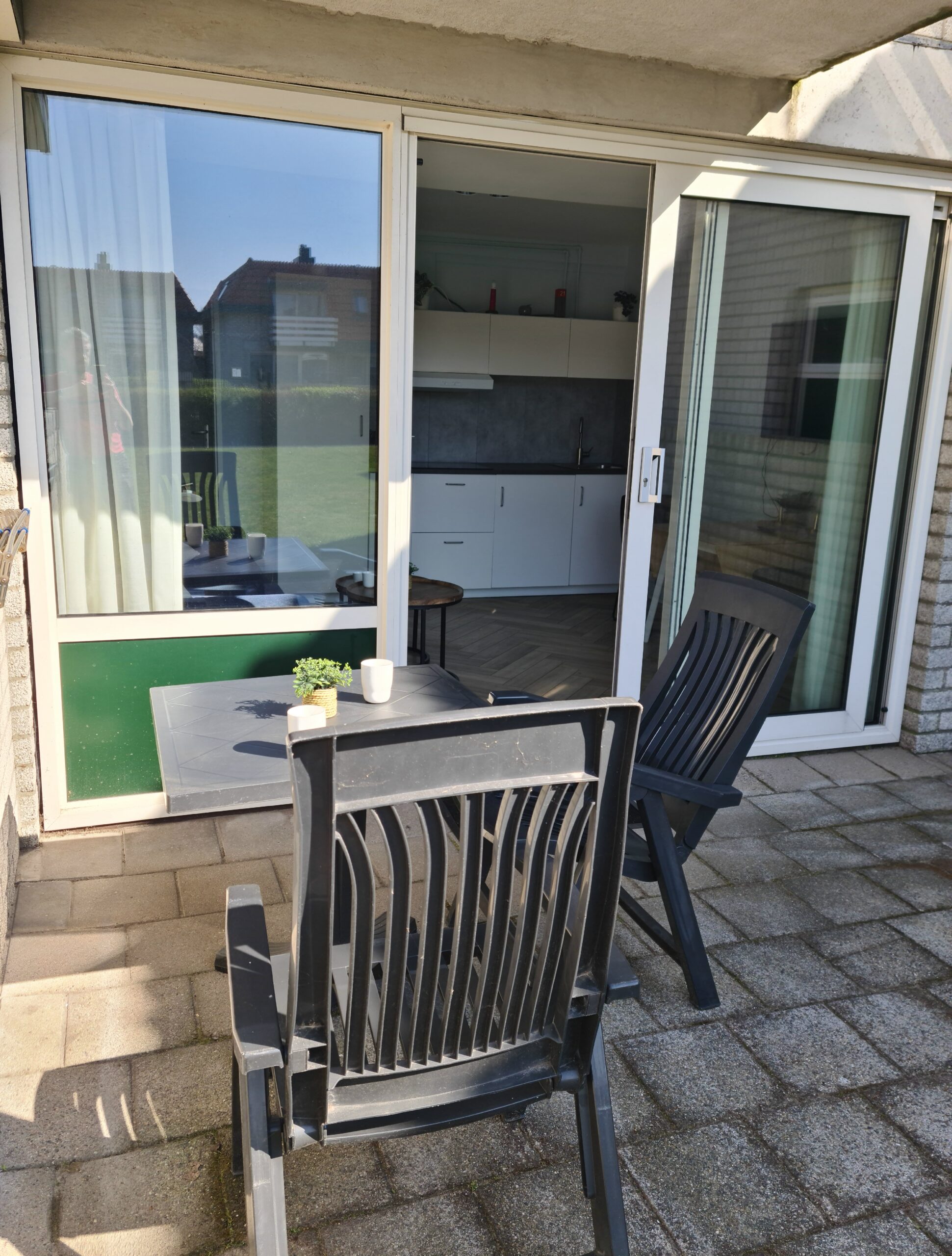 terras tafel en stoelen genomen met op de achtergrond openstaande tuindeuren.