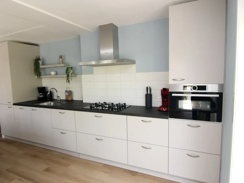 Open keuken met extra groot keukenblok, vaatwasser, ruime ijskast met vriesvakken, 5 pits kookplaat, magnetron en oven.