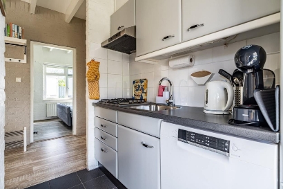 Compacte en praktische keuken met vaatwasser, magnetron, grote koelkast/vriezer.