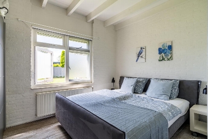 Ruime slaapkamer aan de achterkant met tweepersoons bed en grote kledingkast.