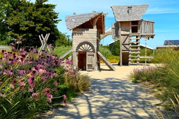 Een van de twee speeltuintjes. Houten klimtorens met glijbaan.