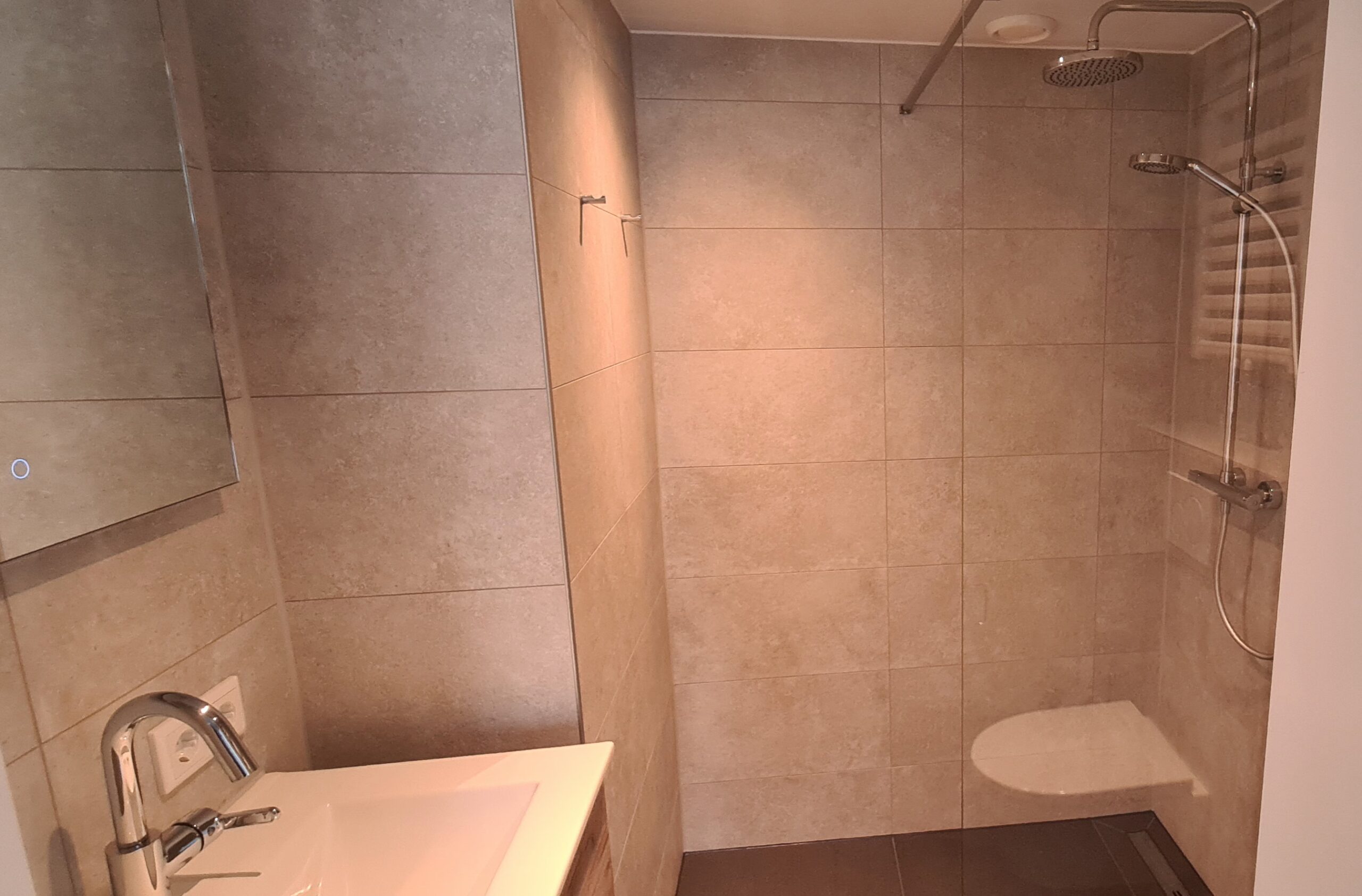 badkamer met wastafel / wandmeubel, toilet, inloopdouche.