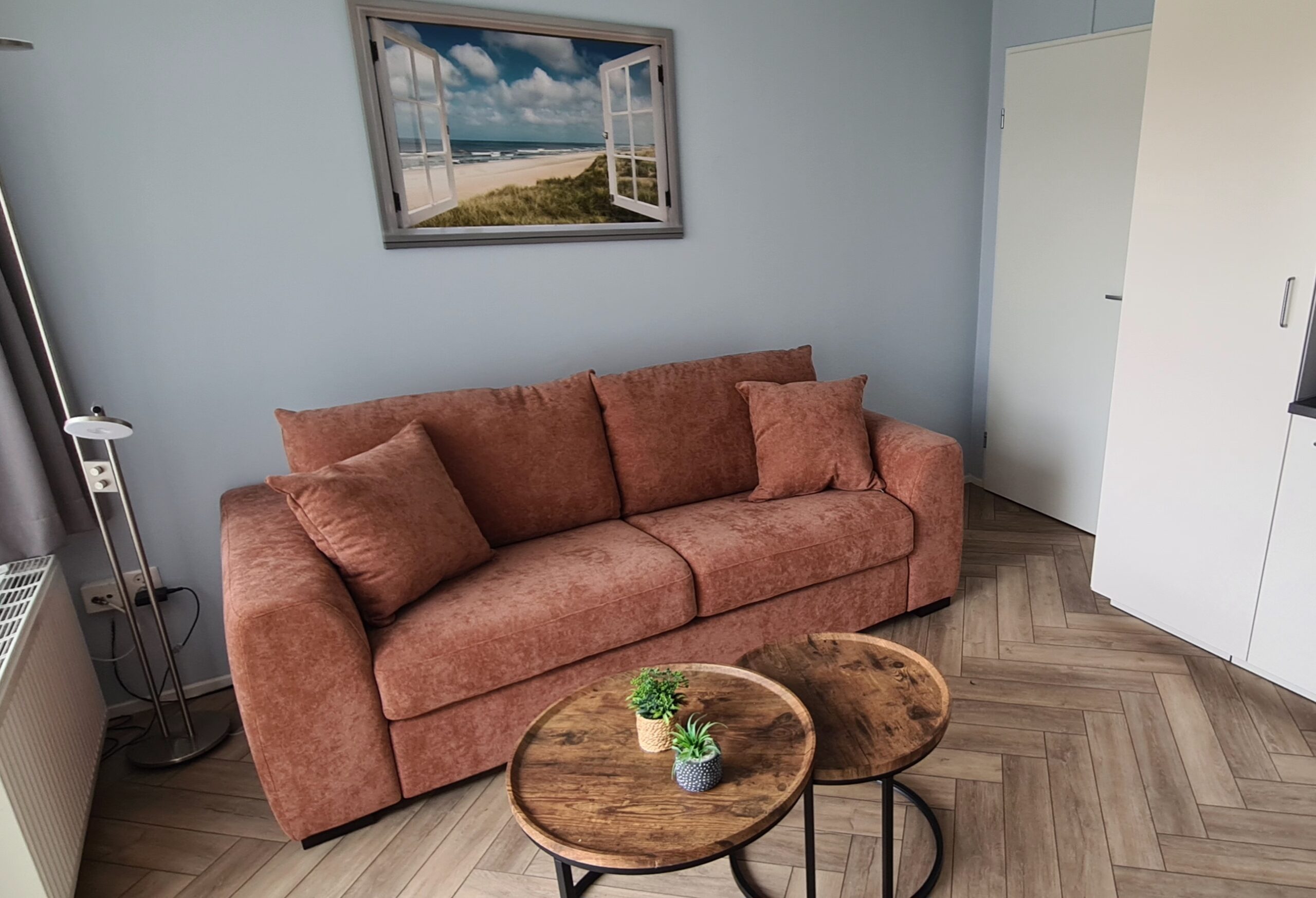 Woonkamer met comfortable bank die uitgeklapt kan worden tot slaapbank.